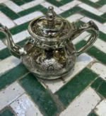 Moroccan silver teapot Traditional tea set Moroccan tea culture Silver teapot design Handcrafted silverware Moroccan decor Artisan teapots Vintage silver teapot Decorative tea accessories Moroccan tea ceremony